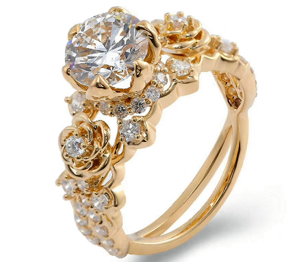 Floral round moissanite engagement ring in solid 14K yellow gold featuring rose-inspired diamond accents and split shank design.
