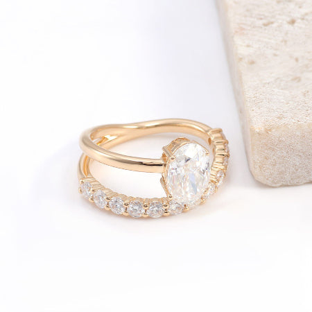 Oval cut moissanite engagement ring set in solid 14K rose gold featuring a curved diamond wedding band and solitaire center stone.