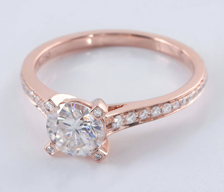 round brilliant moissanite engagement ring in solid 14k rose gold featuring a hidden halo setting and pavé accent band.