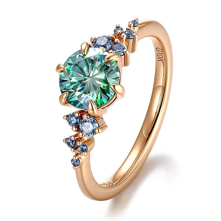 round green moissanite engagement ring in solid 14k rose gold featuring blue sapphire cluster side stones and a nature-inspired setting.