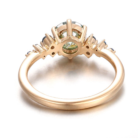 round green moissanite engagement ring in solid 14k rose gold featuring blue sapphire cluster side stones and a nature-inspired setting.