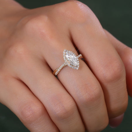 marquise cut moissanite halo engagement ring in solid 14k yellow gold featuring a twisted pavé band and sparkling halo setting