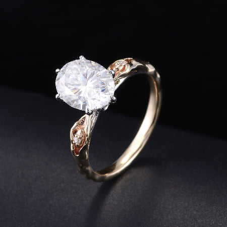 2CT oval cut moissanite engagement ring in 14K rose gold with vintage leaf side accents and six-prong solitaire setting for women.
