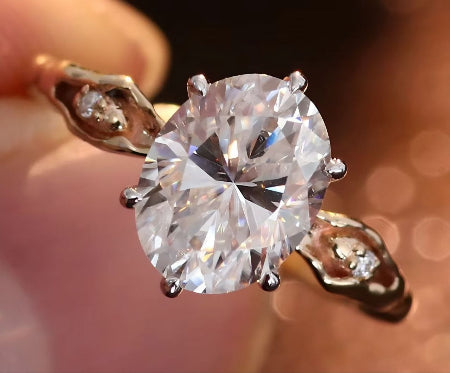 2CT oval cut moissanite engagement ring in 14K rose gold with vintage leaf side accents and six-prong solitaire setting for women.
