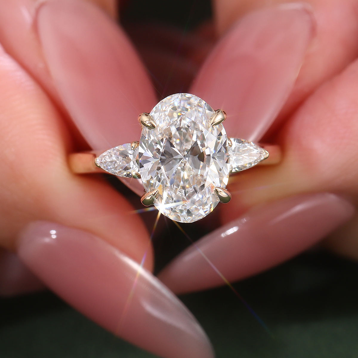 oval moissanite three stone engagement ring with marquise side stones in solid 14k yellow gold