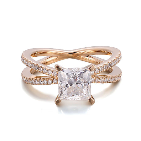 Princess cut moissanite engagement ring with a split shank crossover pavé diamond band in solid rose gold. Elegant solitaire bridal ring for women.