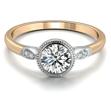 Round bezel set moissanite engagement ring with a two-tone solid gold band and diamond side accents. Modern minimalist solitaire ring for women.