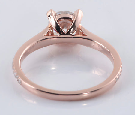 Round brilliant moissanite engagement ring in solid 14K rose gold featuring a hidden halo setting and pavé accent band.