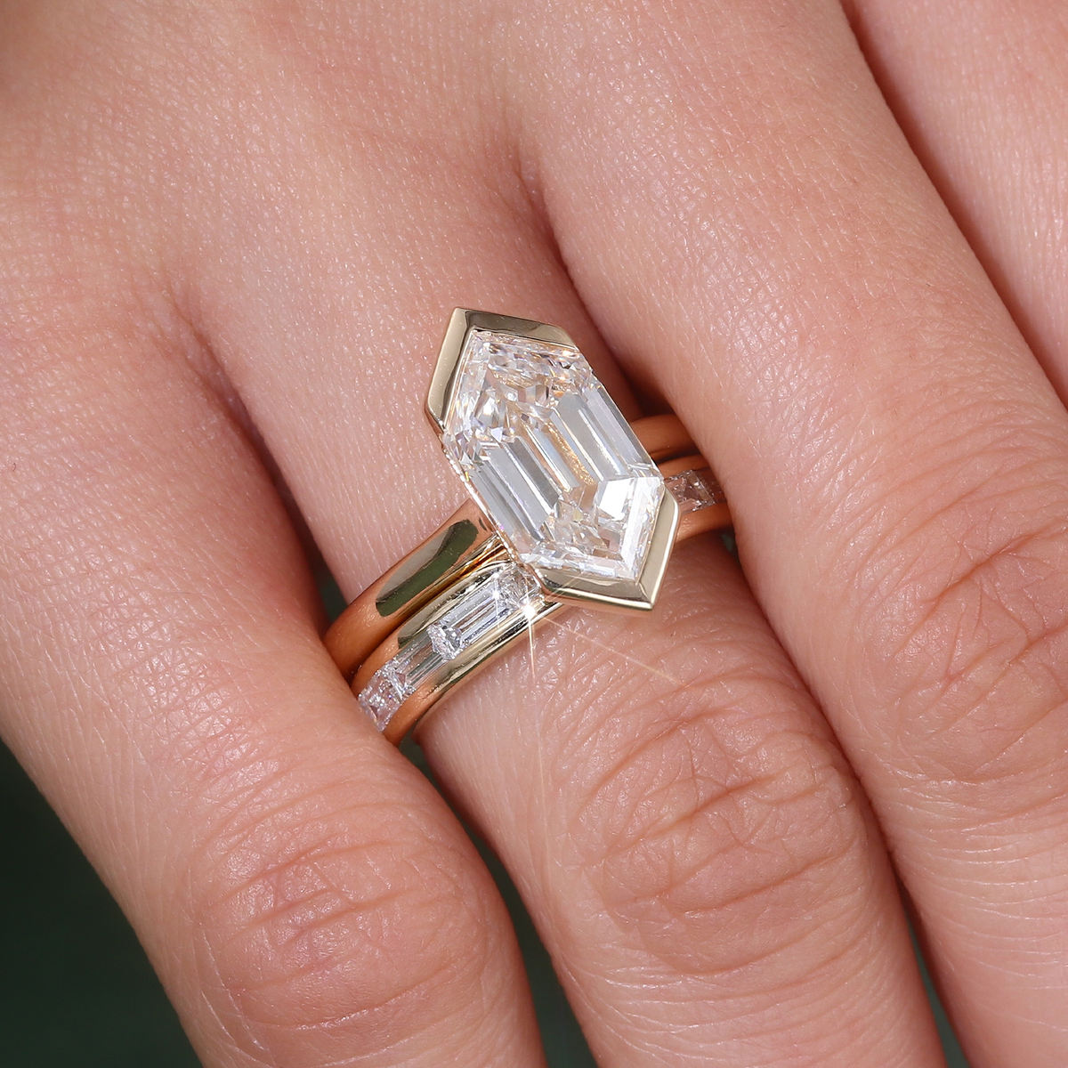 shield cut moissanite engagement ring set in solid 14k yellow gold featuring a bezel-set geometric center stone and matching baguette wedding band