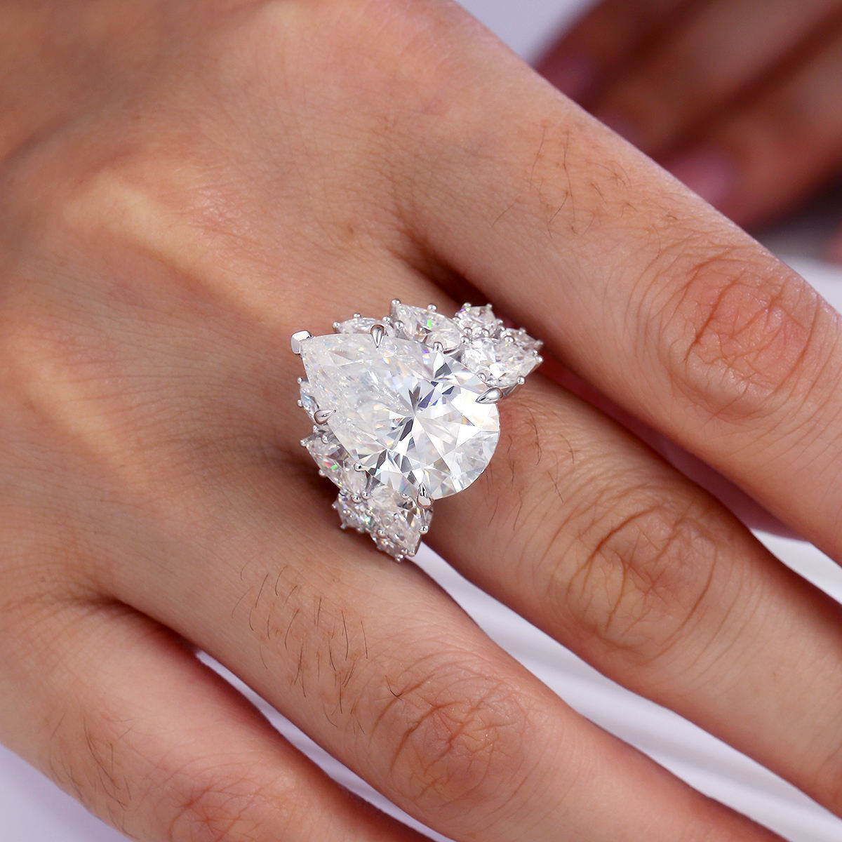 large trillion cut moissanite engagement ring in 925 sterling silver with pear and round moissanite floral cluster side stones